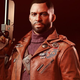 Colt Vahn, Deathloop's protagonist, stands looking at the camera in a stylish orange jacket, a gun in his right hand.